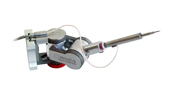 The RoTip rotational-axis plug-in on a Kleindiek micromanipulator, its cylindrical axis holding a long tungsten probe tip.