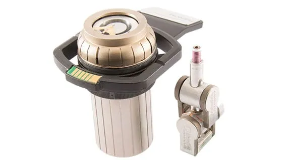 A Phenom sample holder beside the compact MM3A-EM micromanipulator — an upright three-axis arm on a mounting base carrying a probe tip.