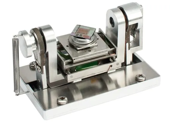 The E5AT stage — a stainless-steel five-axis substage with twin upright bearings cradling a tilting platform that carries a patterned sample chip.