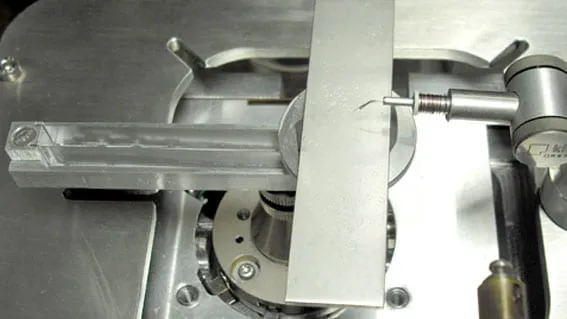 A SpringTable mounted on an SEM stage with a probe needle positioned against its free end, ready to deflect it.
